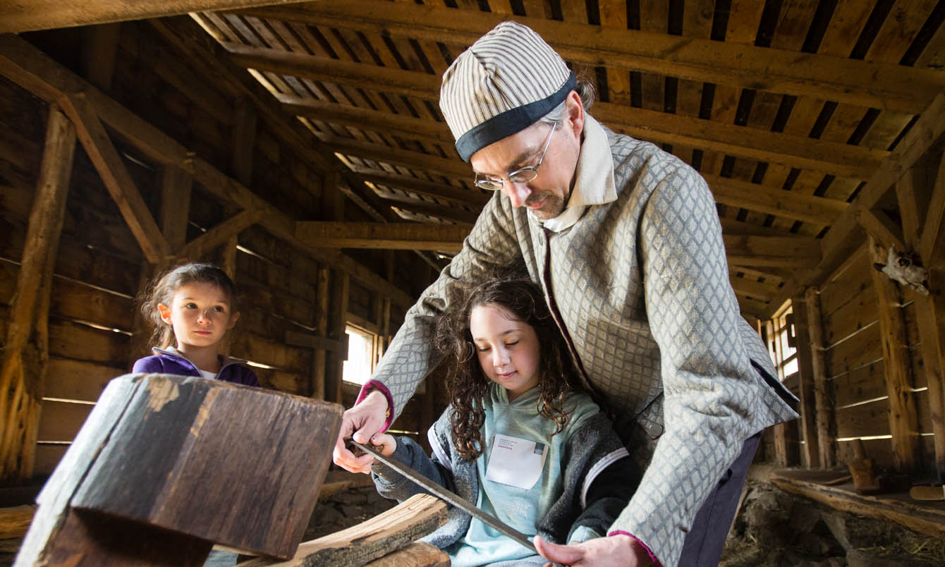 An interpreter and a student visitor making shingles at Philipsburg Manor
